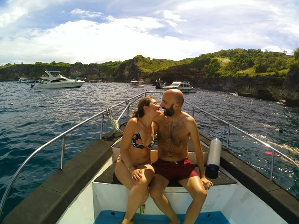 Pareja compartiendo un momento romántico en el barco durante el tour de snorkel en Nusa Penida, escapada en Bali
