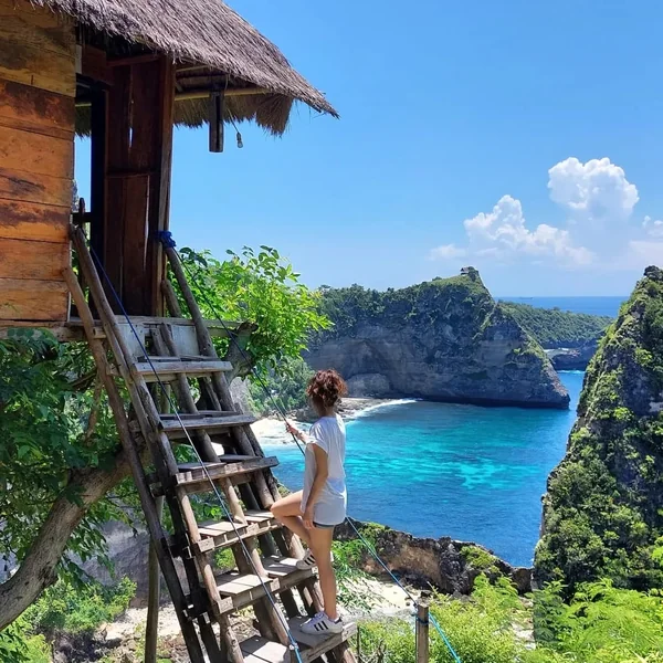 Casa árbol Rumah Pohon de madera con techo de palma colgada sobre los acantilados de Atuh con vista a Diamond Beach en Nusa Penida