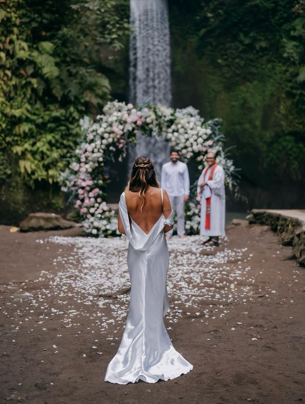 Boda balinesa junto a cascada en Bali — ceremonia hindú con arco de flores