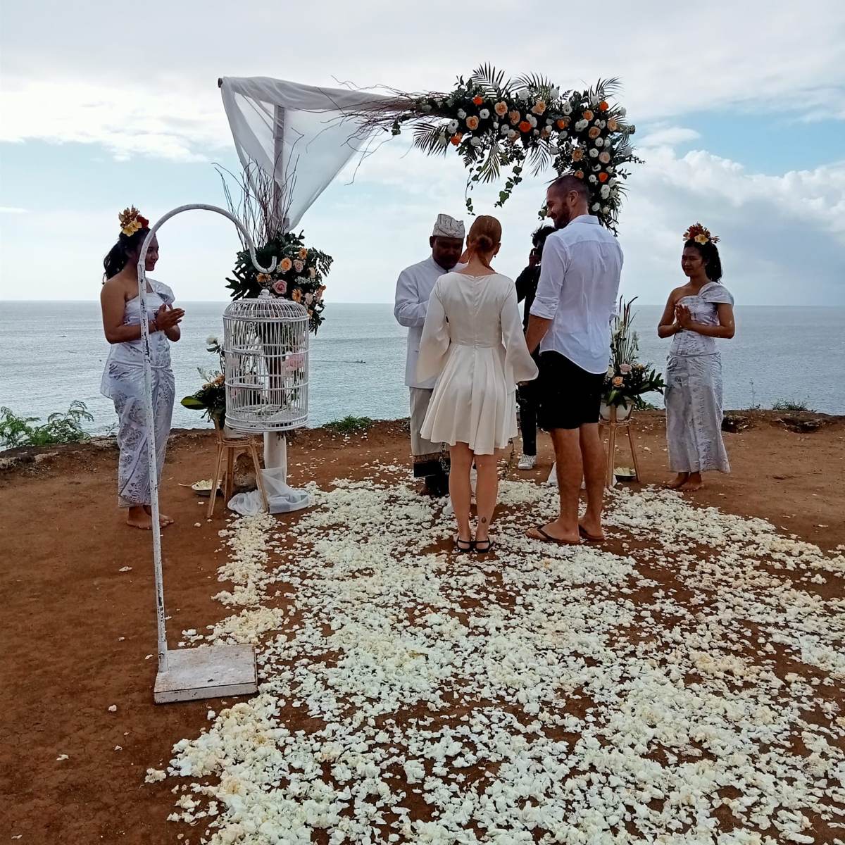 Ceremonia de boda balinesa en acantilado con vistas al mar y damas balinesas