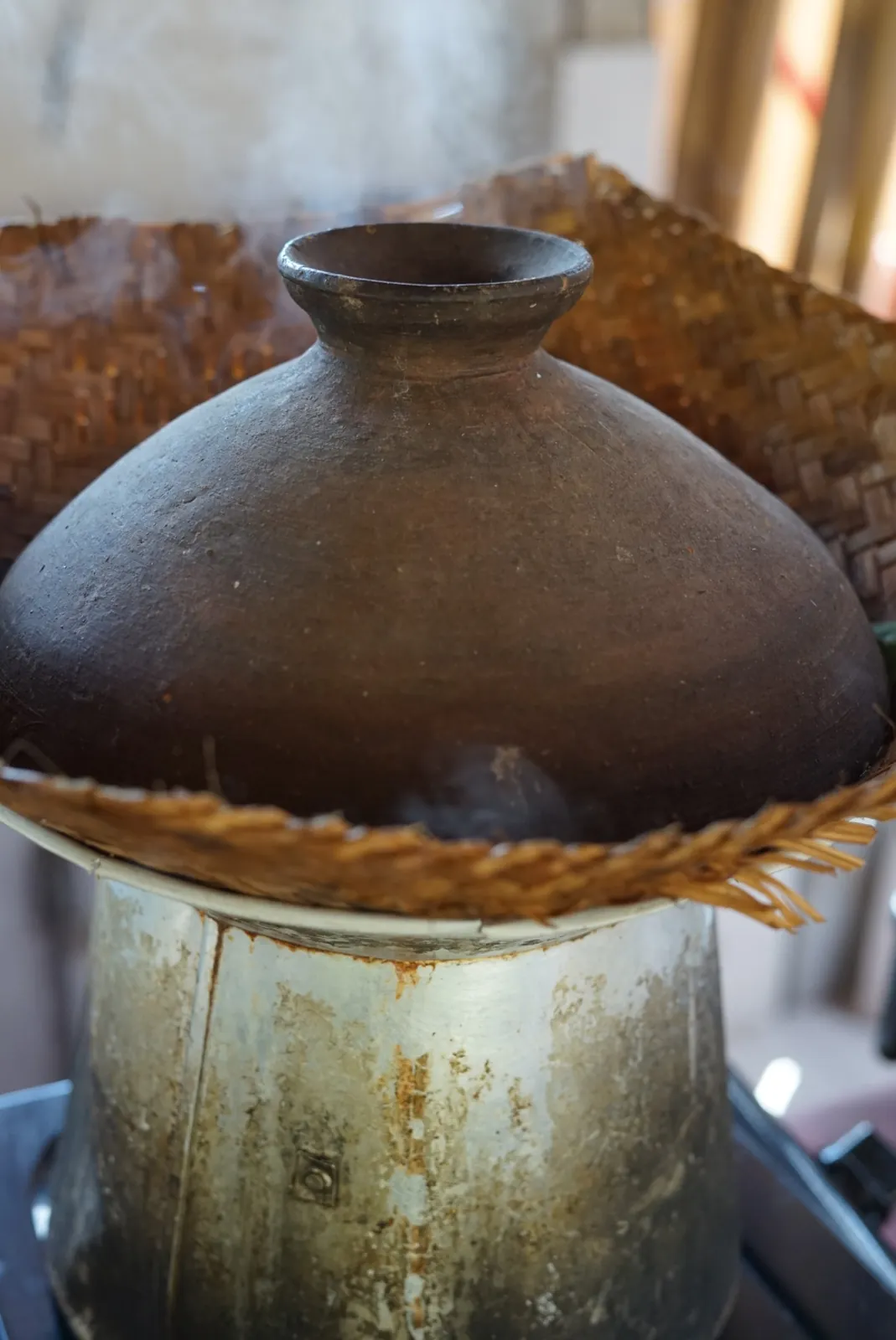 Olla de barro tradicional balinesa cociendo arroz al vapor sobre fogón