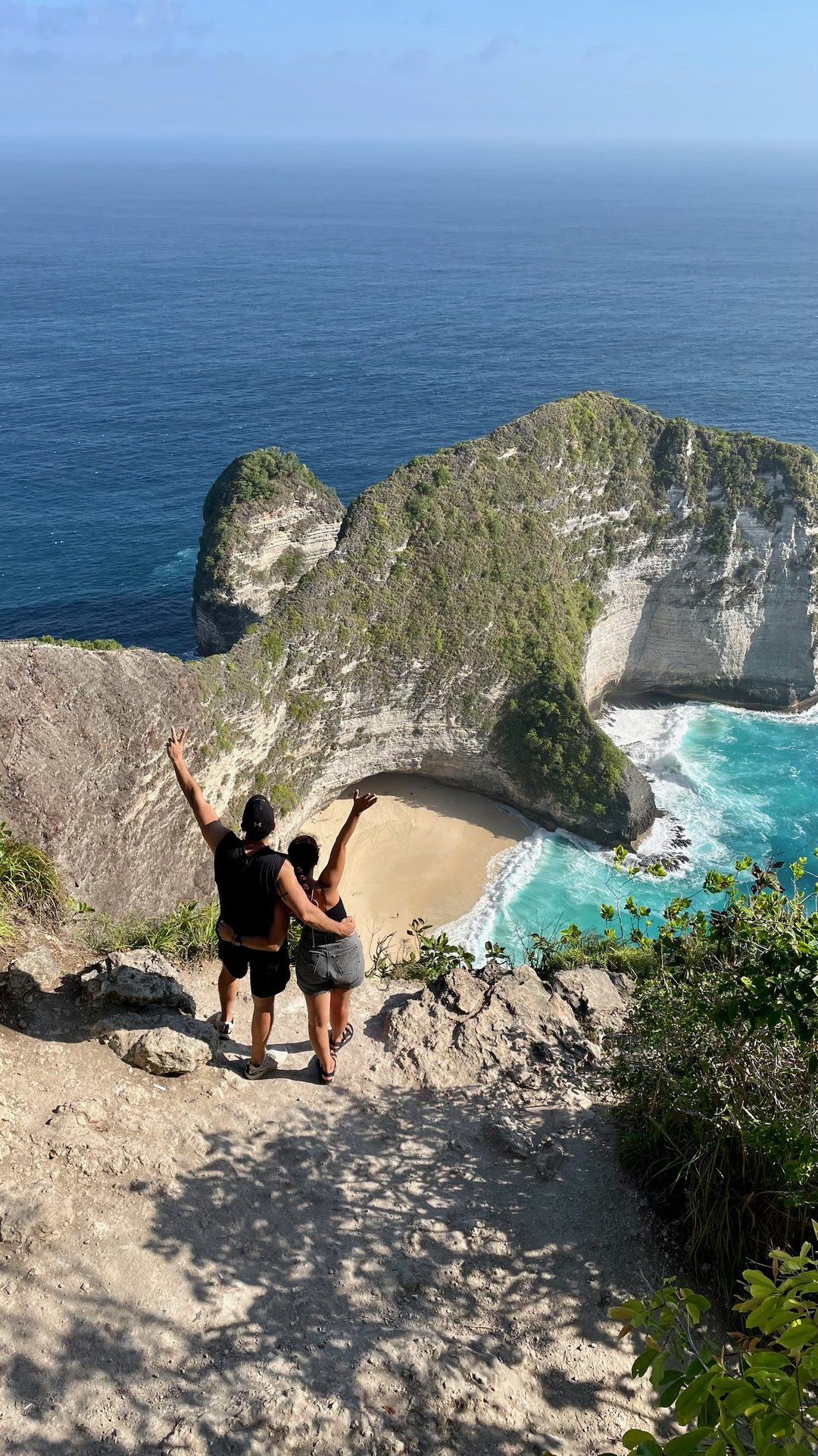 Nusa Penida Kelingking Beach pareja espaldas acantilado Bali
