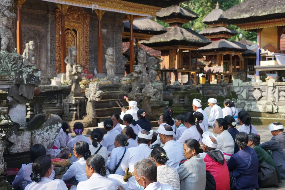 Ceremonia balinesa con fieles vestidos de blanco en el templo de Taman Ayun, oeste de Bali