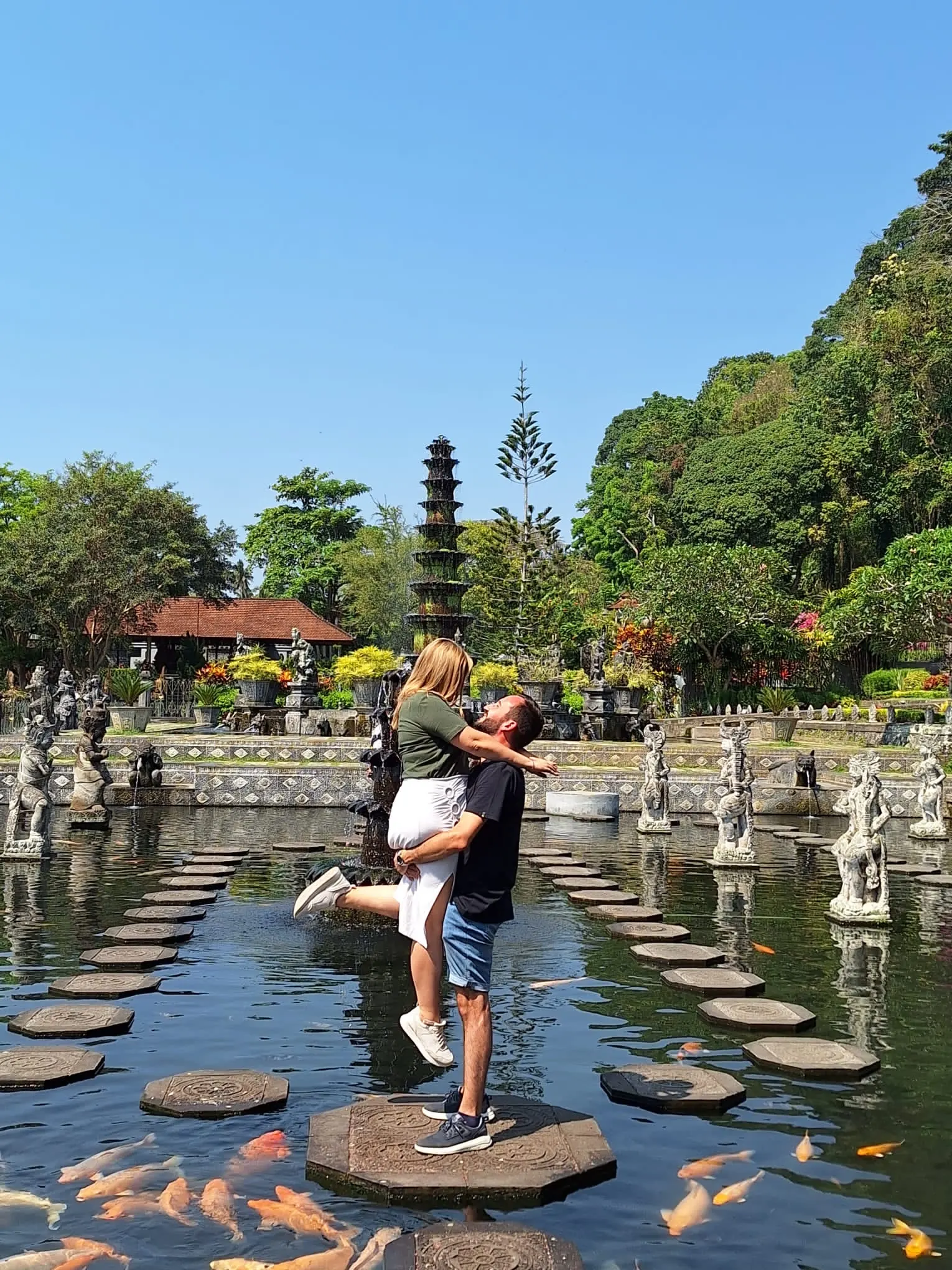 Pareja en su viaje a Bali con En Bali celebrando sobre los estanques de Tirta Gangga, este de Bali