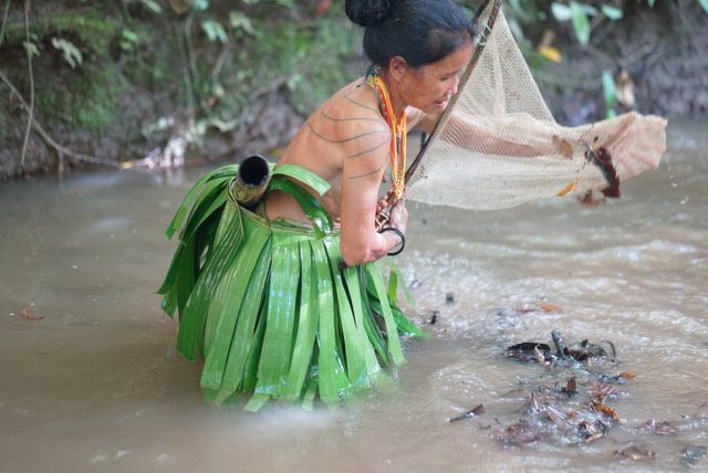 Mujer Mentawai pescando en el río con red tradicional